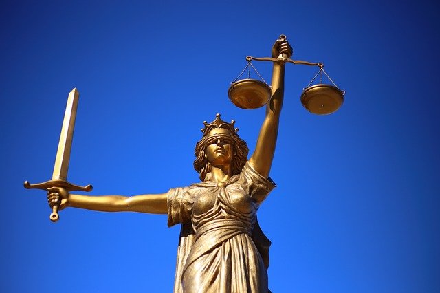 Goldene Justitia vor blauem Hintergrund